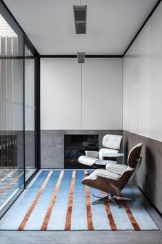 an empty room with a chair, fireplace and large glass doors on the side wall