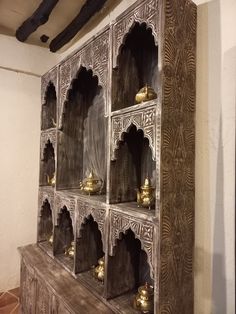 an ornate wooden shelf with gold decorations on it's sides and shelves in the middle