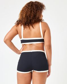 Sail away to somewhere special in the Sailor Shorts. These swim-ready ribbed shorts allow you to get sporty in the water while still showing off thanks to the cheeky style fit and v-front. Wear them with the Taylor or Selena top depending on your desired style. Mid To High Rise Cheeky Boyshort V Front Colorblock Seaming Ribbed Size XS-XL 92% Nylon/8% Spandex Like all delicates, shape, color and fit are best preserved if hand washed in cold water. Lay flat to dry. Style # RHSAF24 Coverage: Bitsy Sporty Short Tankini For Sports, Sporty Black Shorts For Poolside, Black Athleisure Swimwear Shorts, Sporty Black Short Length Swimwear, Sporty Short Stretch Tankini, Black Swimwear For Gym With Short Length, Sporty Short Length Tankini For Poolside, Casual Short Length Tankini For Sports, Stretch Summer Shorts Bra Friendly