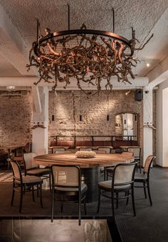 a dining room table with chairs and a chandelier hanging from the ceiling