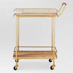 a gold metal and wood serving cart