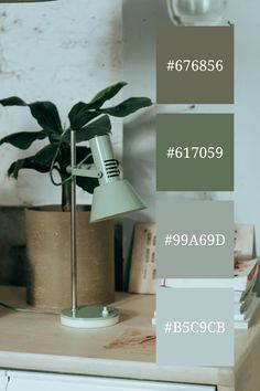 a table with a lamp and some books on it next to a potted plant