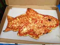 a fish shaped pizza sitting in a box