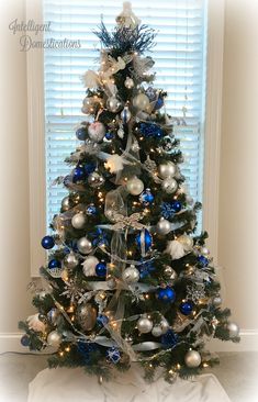 a decorated christmas tree with blue and silver ornaments