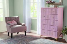 a pink chair sitting in front of a dresser