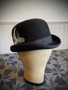 "Classic Black Derby/Bowler Hat - Custom Made by Reed Hill LTD. Wappinger Falls, NY                                                                                                      who is no longer in business. Lovely collectors' piece or still very wearable - comes in the original cardboard insert. This dapper hat is made of black fur blend and has a black grosgrain ribbon with side bow. Jaunty feather accent in tight derby rim is removable. This is a fine vintage hat in great condition as shown.  Measures approx. 20 1/4\" inside band of hat. Size is 6 1/2 - 52." Black Derby Hat With Short Brim, Black Short Brim Hat For Derby, Black Brimmed Top Hat For Derby, Classic Black Hat For Derby, Black Top Hat For Derby, Classic Black Derby Hat, Adjustable Brimmed Hat For Derby, Adjustable Top Hat With Short Brim For Derby, Black Flat Brim Top Hat For Derby