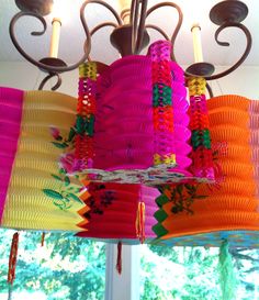 colorful paper lanterns are hanging from a chandelier