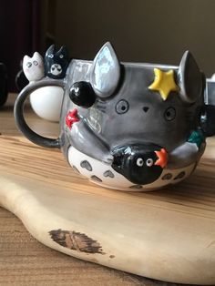 a ceramic animal mug sitting on top of a wooden board