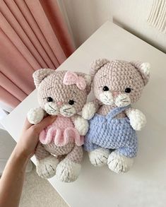 two crocheted teddy bears sitting next to each other on top of a table