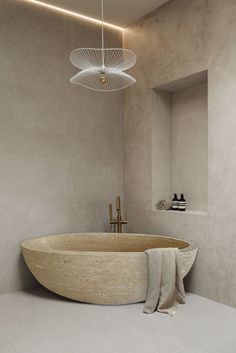 a bath room with a large tub and a light hanging from the ceiling above it