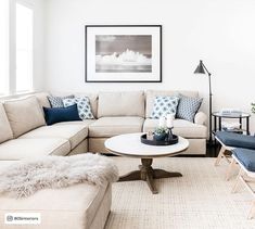 a living room filled with furniture and a white rug on top of a hard wood floor