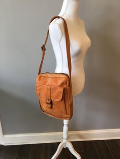 "Vintage glove leather carry all/ tote! Light caramel color soft leather carry all! Bag offers one compartment on exterior and one large zippered compartment. Bags label reads \"Made in Columbia \". Bag has a metal zip and tarnished brass buckles. Great looking unisex leather bag.  Dimensions- 12 1/2 inches tall - 10 inches across- 3 inches deep- 15 inch strapping, adjustable  Condition- great vintage- all hardware fully functional, leather has a few scuffs and  few light stains from normal wear Please do not hesitate to ask questions as all sales are final and thanks for stopping by" Messenger Bag Leather, Vintage Gloves, Caramel Color, Leather Messenger Bag, Brass Buckle, Carry All Bag, Leather Messenger, Messenger Bags, Leather Gloves