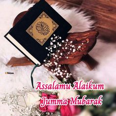 an islamic book on top of a wooden stand next to flowers and a white rug