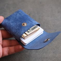 a hand holding a wallet with money sticking out of the front and side pockets on both sides