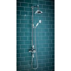 a shower head with thermostaer and handset in front of a blue tiled wall