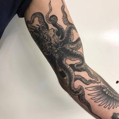 an octopus and bird tattoo on the left arm is shown in black ink with white background