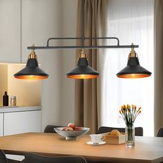 three lights hanging over a dining room table