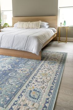 a large bed sitting on top of a wooden floor next to a window in a bedroom