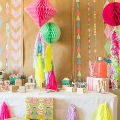 the table is decorated with tissue pom poms and tassels for decoration