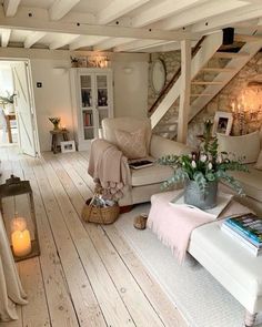 a living room filled with furniture and a fire place next to a staircase leading up to the second floor