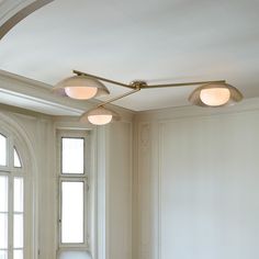 three lights are hanging from the ceiling in a room with white walls and flooring