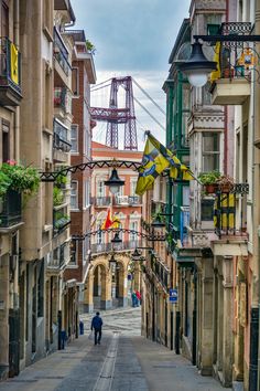 a narrow street with people walking down it