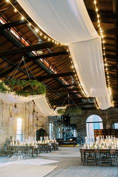 an indoor wedding venue with white draping and candles