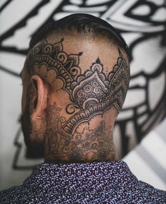 the back of a man's head with intricate designs on his neck and upper part