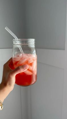 a hand holding a jar filled with liquid