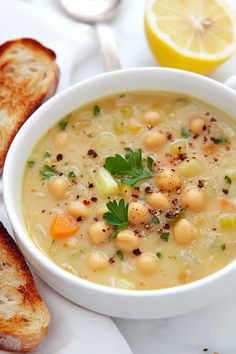 a white bowl filled with soup next to slices of bread