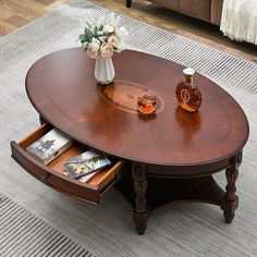 a coffee table with an open drawer underneath it on top of a rug in a living room