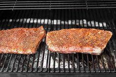 two steaks are cooking on the grill