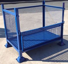 a blue metal fence sitting on the side of a road next to a parking lot