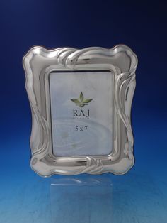 a silver frame with the name raj on it and an image of a leaf