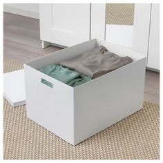 a white box with clothes in it sitting on the floor