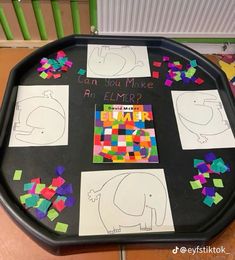 a black tray topped with lots of different colored pieces of paper on top of it