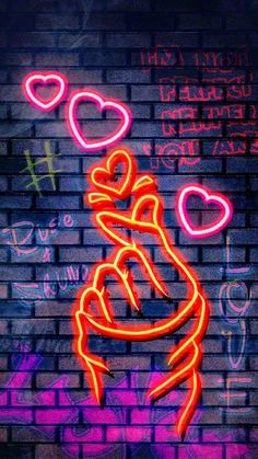 a brick wall with neon signs and hearts on it