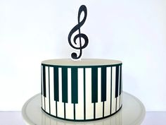 a cake decorated with piano keys and a treble on top is sitting on a plate