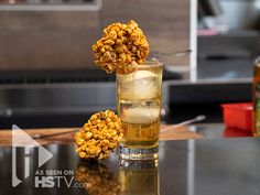 a glass filled with some kind of food on top of a table next to bottles