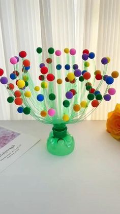 a vase filled with lots of colorful pom - poms on top of a table