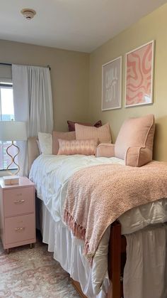 a bedroom with pink and white decor on the walls, bed in front of window