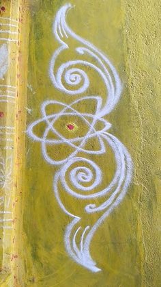 an aerial view of graffiti on the side of a building with white swirls painted on it