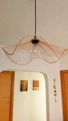 a light fixture hanging from the ceiling above a bed in a room with white walls