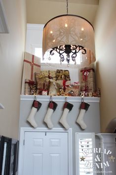 christmas stockings hanging from the ceiling in front of a chandelier