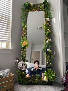 a man is taking a selfie in front of a mirror decorated with plants and flowers