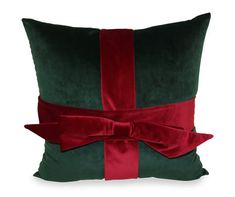 a green and red pillow with a bow on it