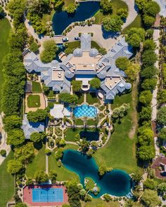 an aerial view of a mansion with a tennis court