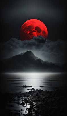 a red moon is seen over the ocean in this black and white photo with rocks