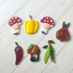 six different colored mushrooms and peppers on a white surface