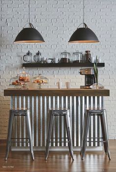 three stools sit in front of an industrial style bar